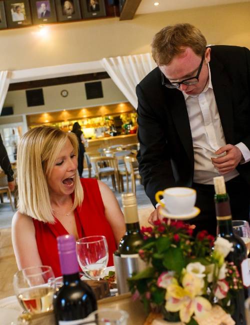 Table magician performing for a woman