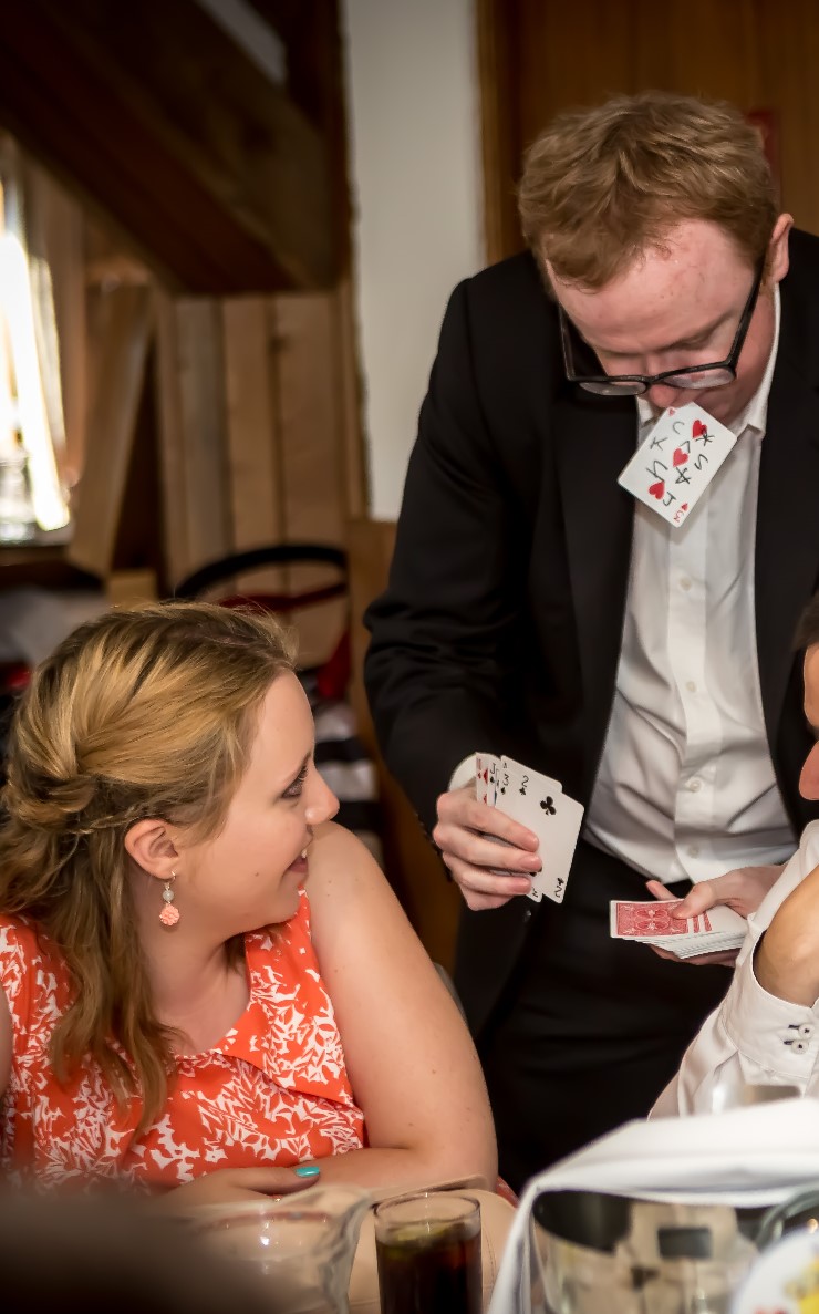 Close up magician with playing card in his mouth